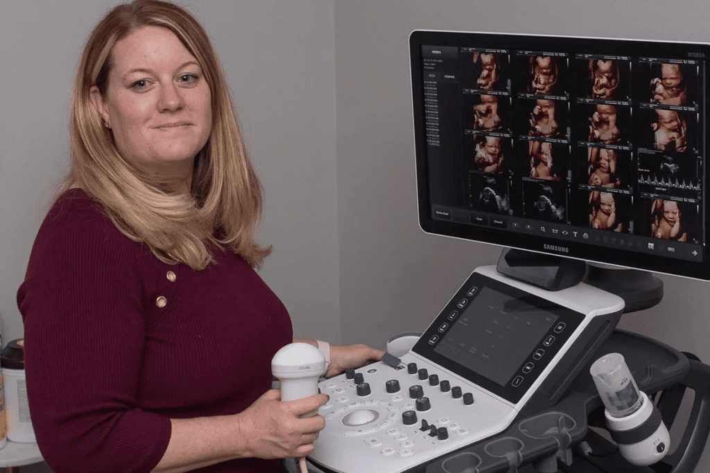 Stormy at Peeping Moms Ultrasound Boutique posing near her Samsung WS80a Elite Ultrasound Machine.